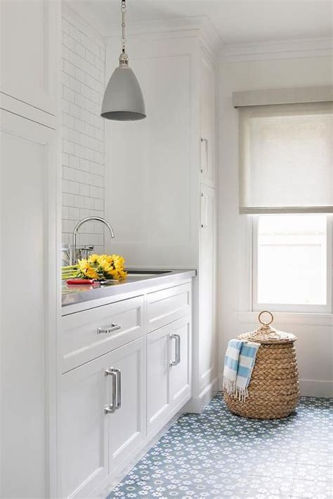 White laundry room designed with gray and blue accent colors seen on  