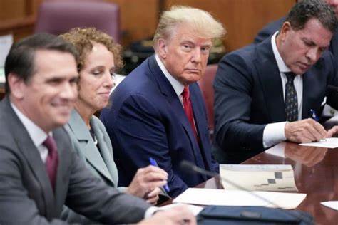 An image of Former US President Donald Trump seated alongiside his team of lawyers