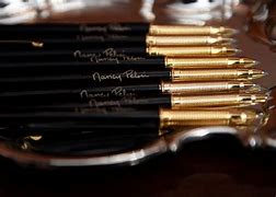 Image result for Pelosi Hands Out Gold Pens