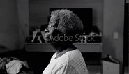 Thoughtful African American Elderly Woman in Bedroom Solitude, monochromatic black and white depicting contemplative older lady staring at window