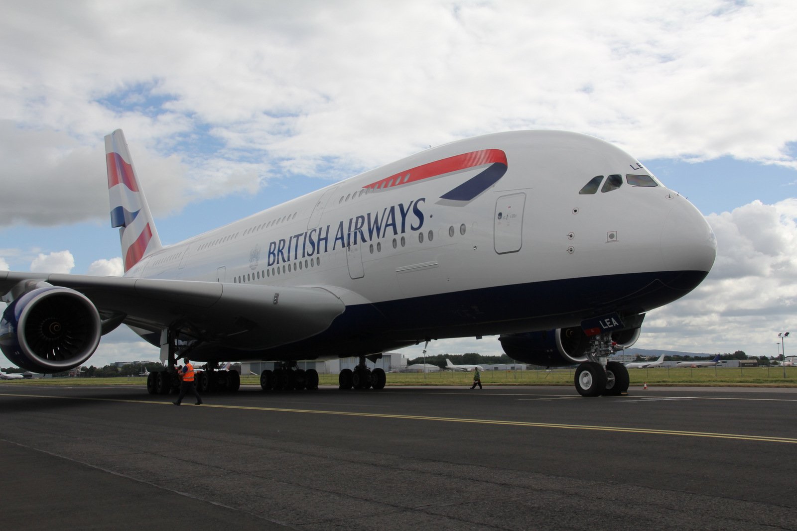 British Airways grounded plane against a blue and cloudy sky