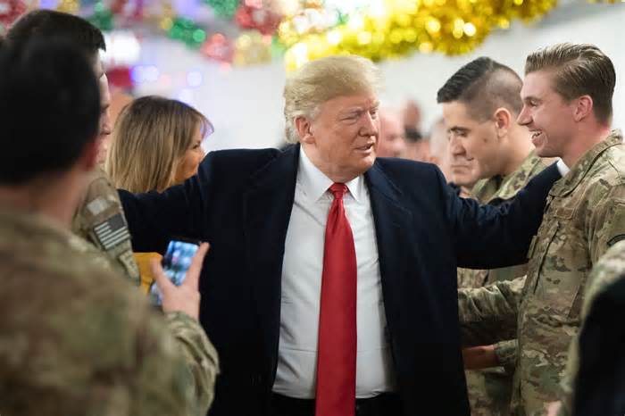 Donald Trump and Melania Trump greet members of the US military during an unannounced trip to Al Asad Air Base in Iraq