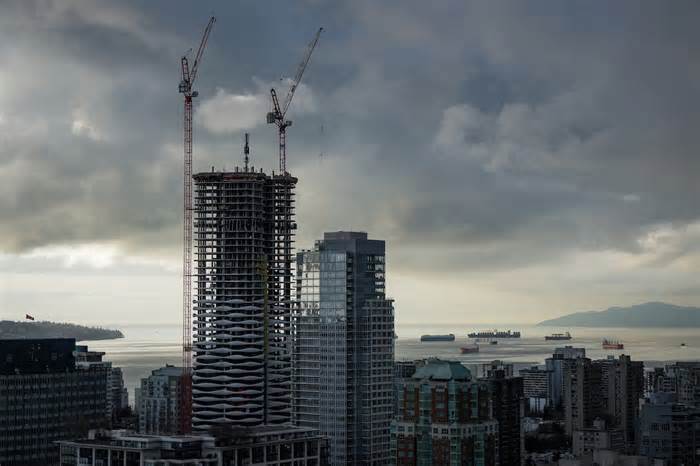 Cranes rise above a condo tower under construction in downtown Vancouver.