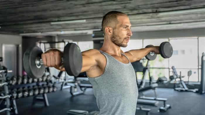 Man performing a lateral raise with dumbbells