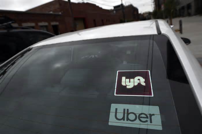 Lyft and Uber stickers on a car.