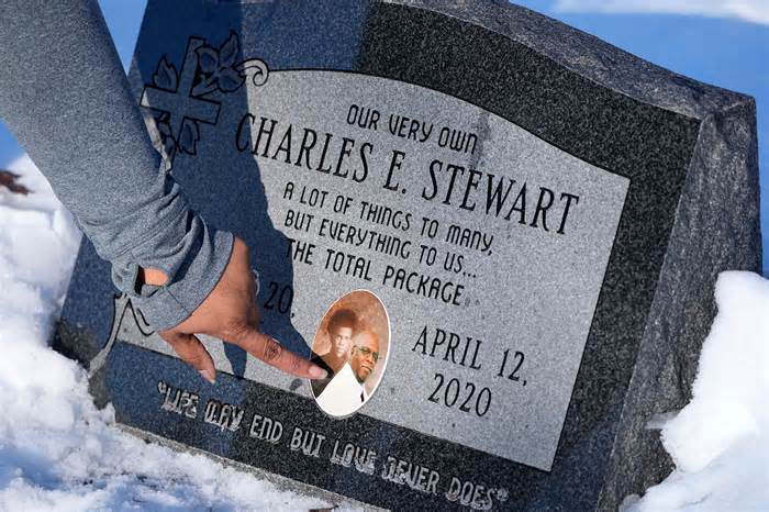 Tomecka Wilkes points out a photo of her father, Charles Stewart, as a senior at Rufus King High School in 1974 and a more recent image, as she visits her father's grave site at Graceland Cemetery in Milwaukee on March 15, 2023. Wilkes lost her father to COVID on April 12, 2020, before a vaccine was available.