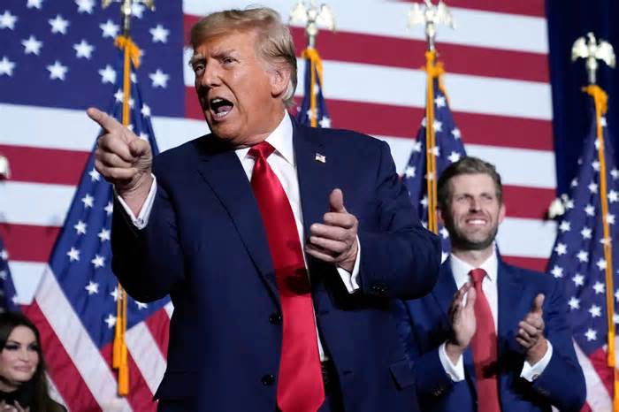 Republican presidential candidate former President Donald Trump points to the crowd with son Eric at a caucus night party in Des Moines, Iowa, Monday, Jan. 15, 2024. (AP Photo/Andrew Harnik) ORG XMIT: IAAH379