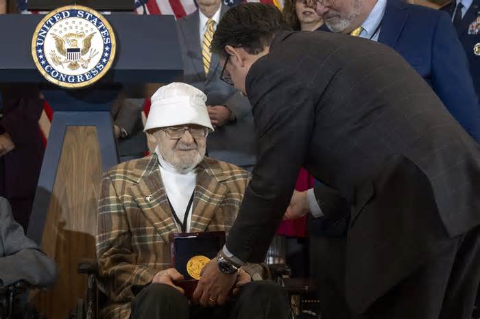 House Speaker Mike Johnson, R-La., right, presents Ghost Army member Bernard Bluestein, of Hoffman Estates, Ill., with a medal during a ceremony to honor members of the secretive WWII-era unit with the Congressional Gold Medal during a ceremony on Capitol Hill, Thursday, March 21, 2024, in Washington. (AP Photo/Mark Schiefelbein)