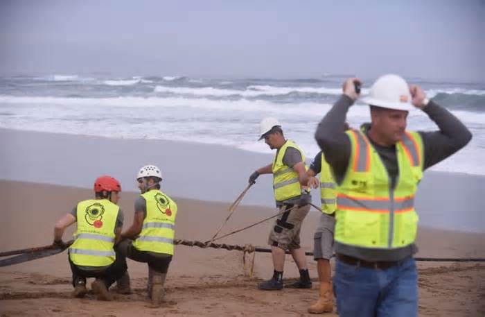 Workers operate on an (unrelated) lead line connected to fiber optic cable at Arrietara beach, near Bilbao, northern Spain, June 13, 2017, as Facebook Inc. and Microsoft Corp. join forces to build an underwater fiber optic cable across the Atlantic Ocean, linking Europe and the USA.