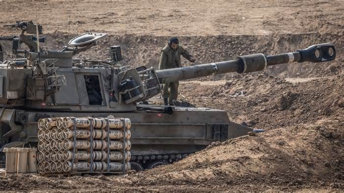 An Israeli soldier stands on artillery near the border with Gaza during Israeli bombardment in Sderot, Israel on October 28, 2023. - Ilia Yefimovich/picture-alliance/dpa/AP