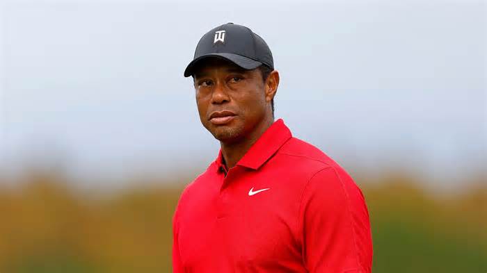 Tiger Woods smiles in his iconic Sunday red Nike Polo shirt at the PNC Championship in 2023