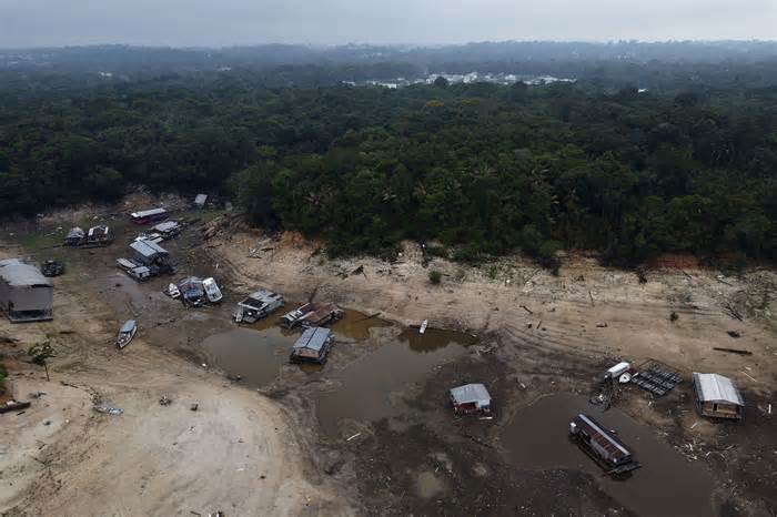 Boats and houseboats are stuck in a dry area of the Negro River during a drought in Manaus, Amazonas state, Brazil, Monday, Oct. 16, 2023. The Amazon’s second largest tributary on Monday reached its lowest level since official measurements began near Manaus more than 120 years ago. (AP Photo/Edmar Barros)