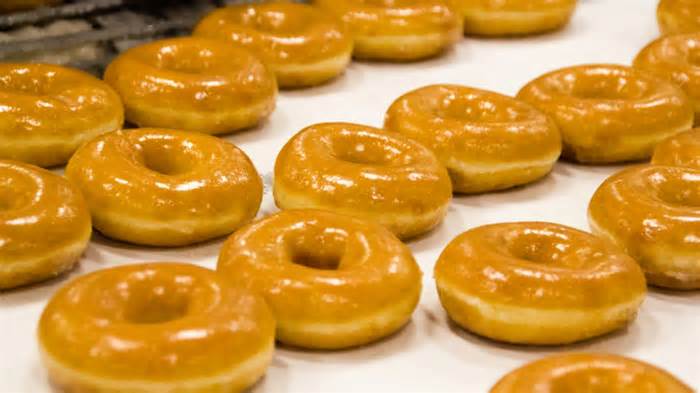 A large tray full of Krispy Kreme glazed doughnuts.
