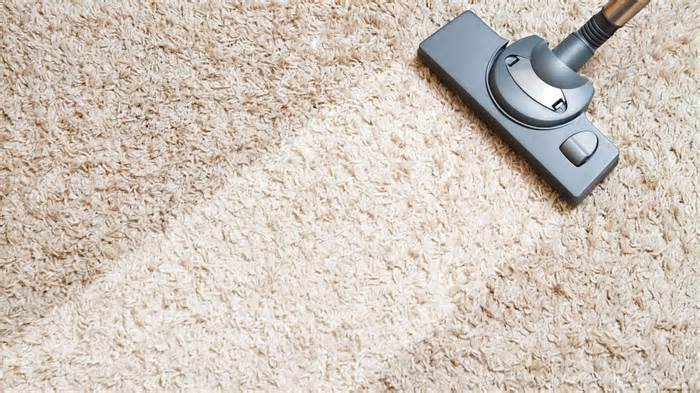 Vacuuming beige carpet