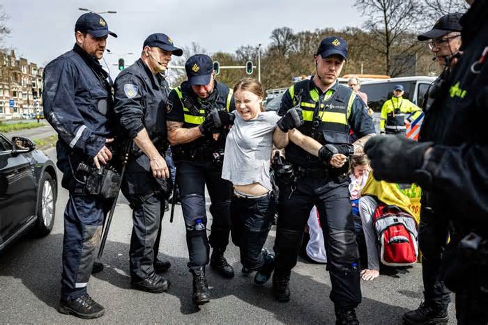 Swedish climate activist Greta Thunberg (C) is detained by police officers during a climate demonstration blocking the A12 highway in the Hague, the Netherlands, on Saturday. Thunberg joined the 37th highway blockade called by the Extinction Rebellion as new international actions against fossil subsidies were announced during the action.