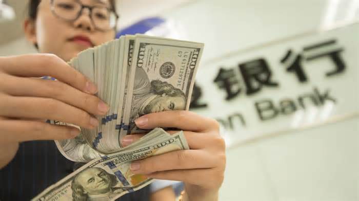 A Chinese clerk counts US dollar notes at a bank in Hai'an city in east China's Jiangsu province on August 6, 2019. - Xu jingbai/ICHPL Imaginechina/AP