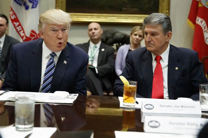 FILE - Sen. Joe Manchin, D-W.Va., right, listens at right as then-President Donald Trump speaks during a meeting with Senators on his Supreme Court Justice nominee Neil Gorsuch, Feb. 9, 2017, in the Roosevelt Room of the White House in Washington. Manchin said Wednesday, Nov. 15, 2023, that if voters give Trump another term in Washington, “he will destroy Democracy in America.” (AP Photo/Evan Vucci, File)