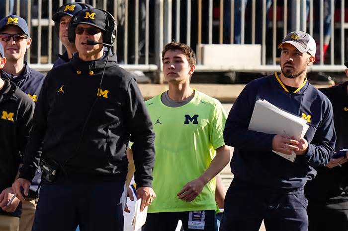 Michigan Coach Jim Harbaugh stands on the field beside off-field analyst Connor Stalions during a game at Ohio last season.