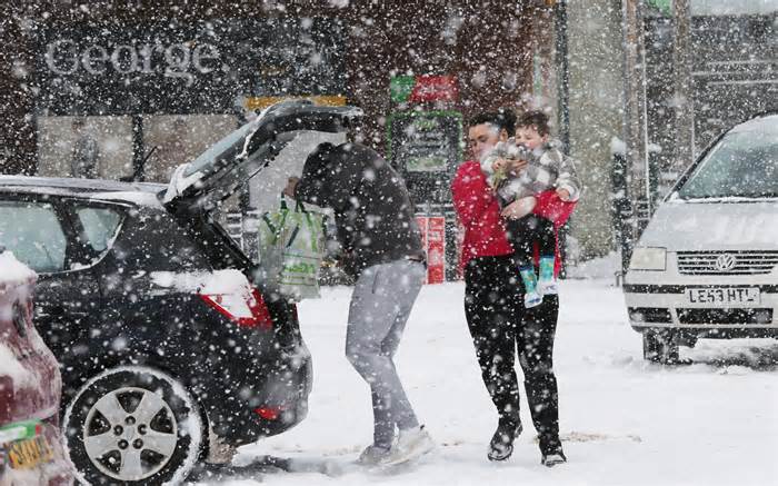 A family caught in a snow blizzard in an Asda car park in Scotland