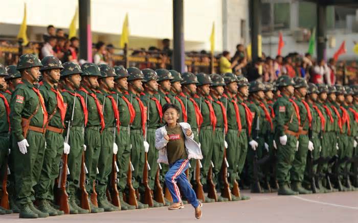 A young girl runs past a Wa State military parade