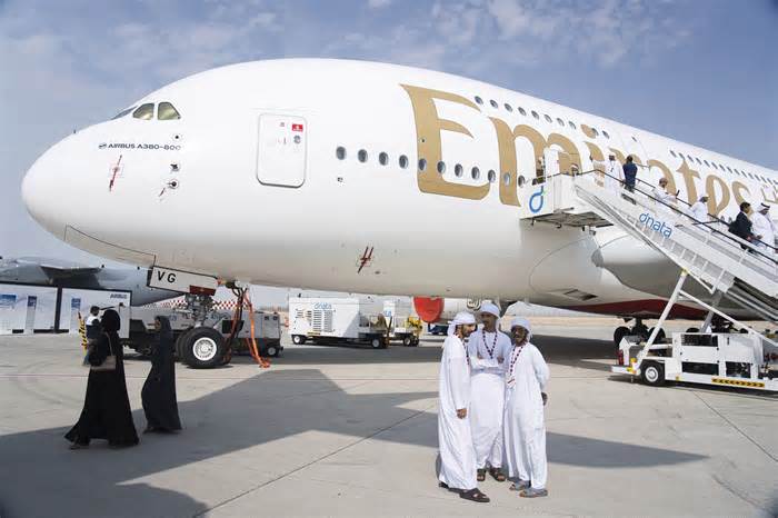 Emirati men stand in front of an Emirates' Airbus A380 double-decker jumbo jet at the Dubai Air Show in Dubai, United Arab Emirates, Thursday, Nov. 16, 2023. Long-haul carrier Emirates said Thursday it will purchase 15 additional Airbus A350-900s worth $6 billion after a spat between the airline and the European manufacturer went unusually public during this week's Dubai Air Show. (AP Photo/Jon Gambrell)