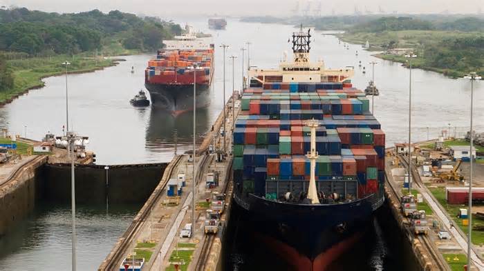 Several freighters, assisted by tugboats, are entering the Panama Canal at Gatun Locks on the Atlantic side.