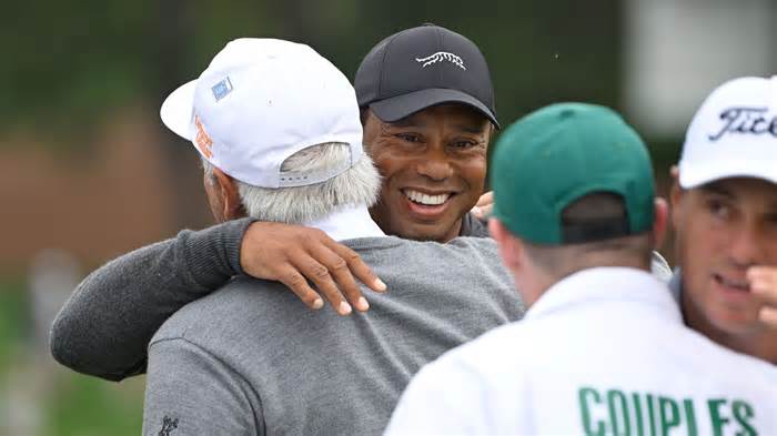 Tiger Woods and Fred Couples embrace on the 9th green after their Tuesday morning practice round.