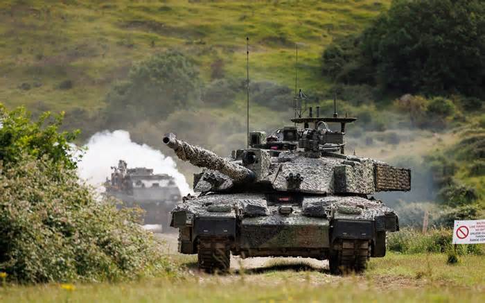A Challenger 2 tank storms down a track on Lulworth Range in Dorset