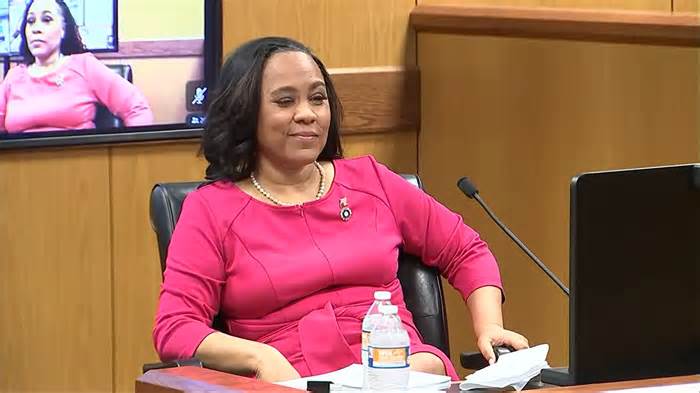 Fulton County DA Fani Willis winks before being sworn in to testify on the hearing about an allegedly improper relationship with Nathan Wade