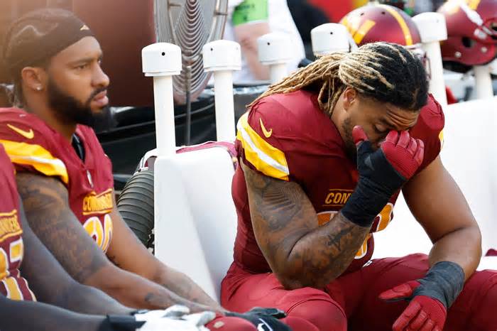 Washington Commanders defensive end Chase Young (99) and Commanders defensive end Montez Sweat (90) sit on the bench against the Philadelphia Eagles during the fourth quarter at FedExField.