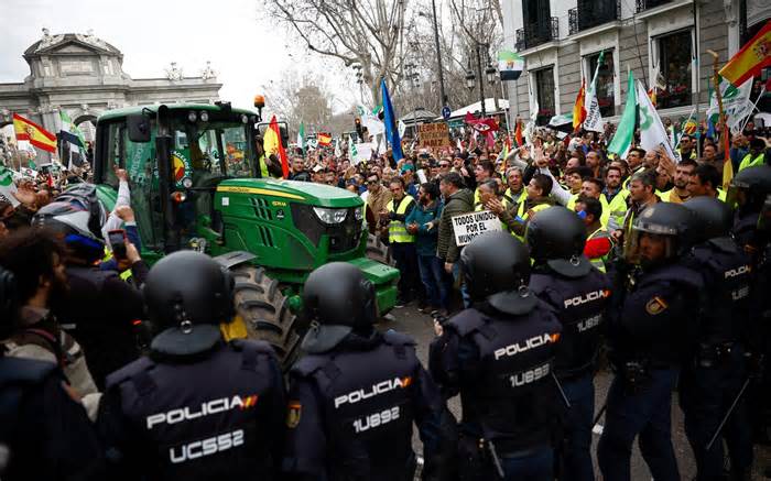 Police members stand guard as Spanish farmers protest over price pressures