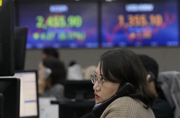 FILE - A currency trader watches monitors at the foreign exchange dealing room of the KEB Hana Bank headquarters in Seoul, South Korea, on Oct. 18, 2023. Asian shares retreated Friday, Oct. 20 as the prospect of a 5% yield on the 10-year U.S. Treasury for the first time since 2007 added to pressure on Wall Street. (AP Photo/Ahn Young-joon, File)