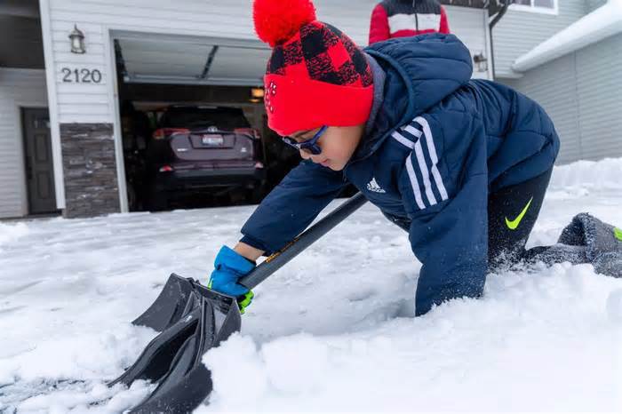 Adyaan Islam, 5, helps his family shovel the driveway in Meridian.