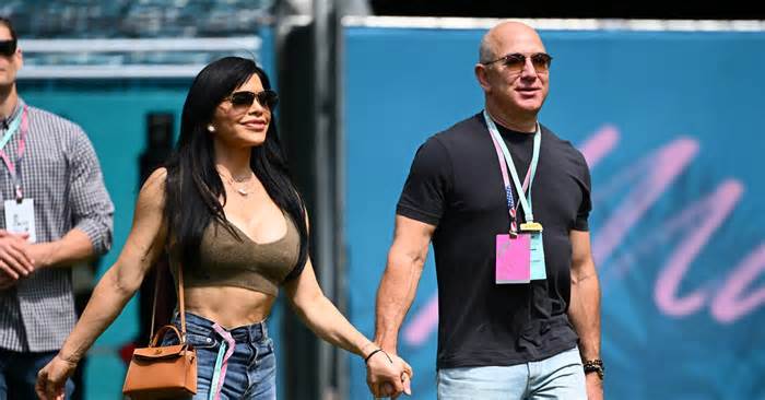Jeff Bezos and Lauren Sanchez walk in the Paddock prior to final practice ahead of the F1 Grand Prix of Miami at Miami International Autodrome on May 06, 2023 in Miami, Florida.