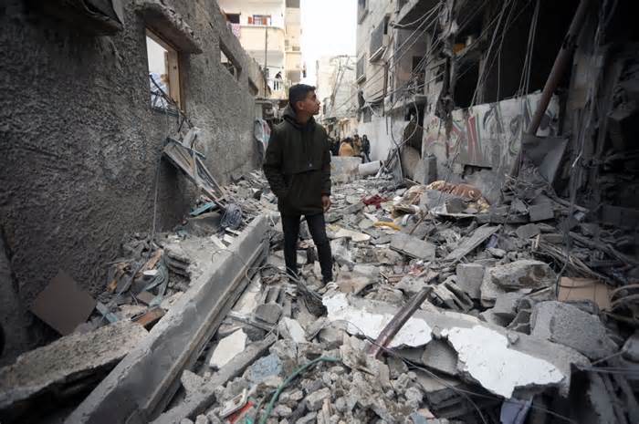 A Palestinian youth stands amid damage to his home caused by Israeli air strikes in Rafah in the southern Gaza Strip on Wednesday. Israeli forces said they have inflicted a 