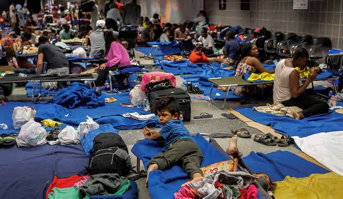 Recently arrived migrants sit on cots and the floor of a makeshift shelter operated by the city at OHare International Airport on Aug. 31, 2023. (Armando L. Sanchez/Chicago Tribune/Tribune News Service via Getty Images)