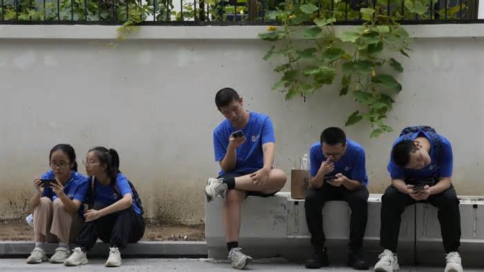 August 2023: Jugendliche schauen in Peking auf ihre Smartphones.