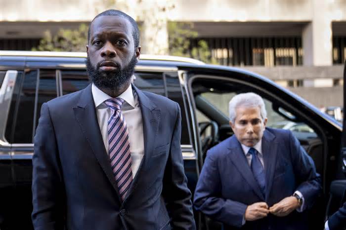 From left, Prakazrel “Pras” Michél, a member of the 1990s hip-hop group the Fugees, accompanied by defense lawyer David Kenner arrives at federal court for his trial in an alleged campaign finance conspiracy on March 30 in Washington.