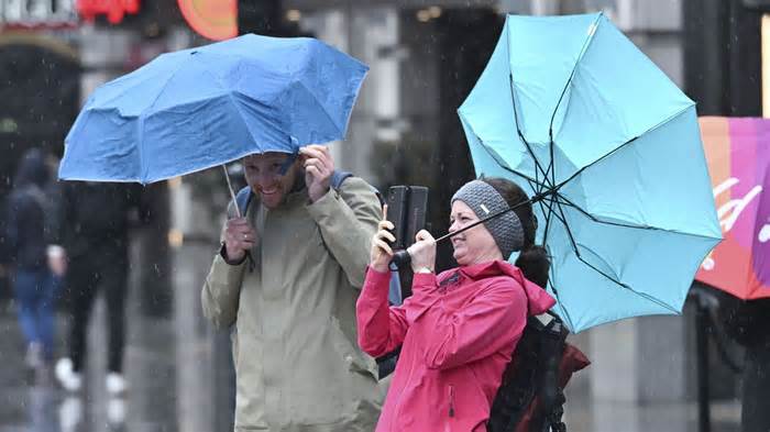 Londoners walk in heavy rain and wind near Piccadilly Circus, London. Pic: Story Picture Agency/Shutterstock