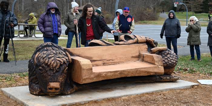 Chain-saw carver Colin Vale this month in Kensington, Md., unveiling the bench he made from the Linden Oak.