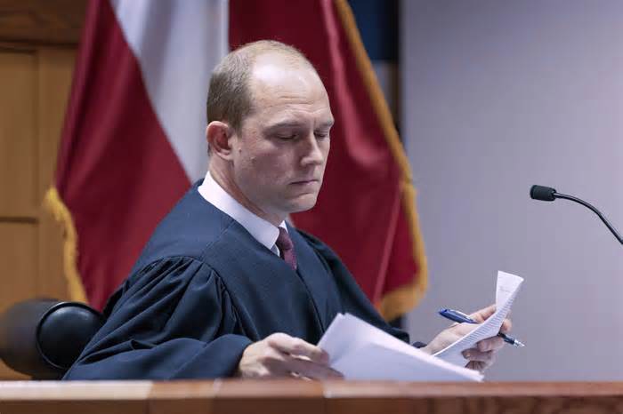 Fulton County Superior Court Judge Scott McAfee presides over a hearing related to the Georgia election indictments, Wednesday, Nov. 15, 2023, at Fulton County Courthouse in Atlanta. Jonathan Miller, an attorney for Misty Hampton, a former elections director charged alongside former President Donald Trump and others over efforts to overturn Georgia’s 2020 election said Wednesday that he released videos of prosecutors’ interviews with some of their codefendants because he thought they helped his client and the public had the right to see them. Prosecutors initially asked the judge to impose an order to prevent the release of any evidence in the case. (Arvin Temkar/Atlanta Journal-Constitution via AP, Pool)
