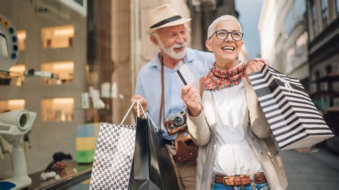 retired senior couple spending money shopping bags vacation_iStock-1002263730
