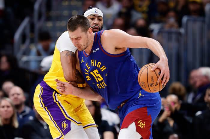 Denver Nuggets center Nikola Jokic controls the ball as Los Angeles Lakers forward Anthony Davis guards in the third quarter at Ball Arena.
