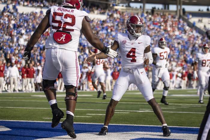 Alabama offensive lineman Tyler Booker (52) and quarterback Jalen Milroe (4) celebrate a touchdown during the second half of an NCAA college football game against Kentucky in Lexington, Ky., Saturday, Nov. 11, 2023. (AP Photo/Michelle Haas Hutchins)