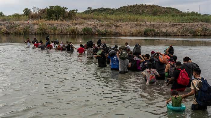 Migrants cross the Rio Grande at the US-Mexico border in Piedras Negras, Coahuila state, Mexico, on Friday, Oct. 6, 2023. Mexico, along with President Joe Biden's administration and the United Nations, is considering setting up a temporary program to help pre-screen tens of thousands of migrants for US entry eligibility as border crossings increase again.