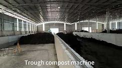 Motor-driven trough compost turner for commercial composting in an organic fertilizer plant.
