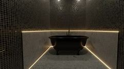 freestanding black bathtub illuminated from yellow led lights