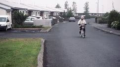 Dramatic SlowMo Of Granny Riding Bike In Foggy, Abandoned Village Free Stock Video Footage Download Clips