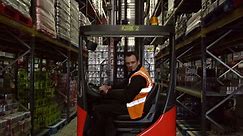 Premium stock video - Forklift driver moving full pallet in warehouse, shot on r3d