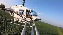 What it looks like crop dusting with a helicopter - spray boom perspective